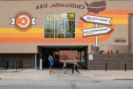 Three people walking in front of a building